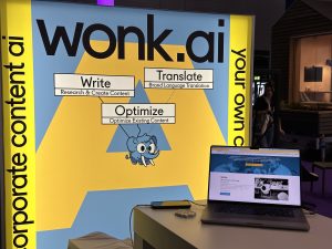 wonk.ai Banner und Laptop auf der DMEXCO 2023 mi Write, Optimize und Translate